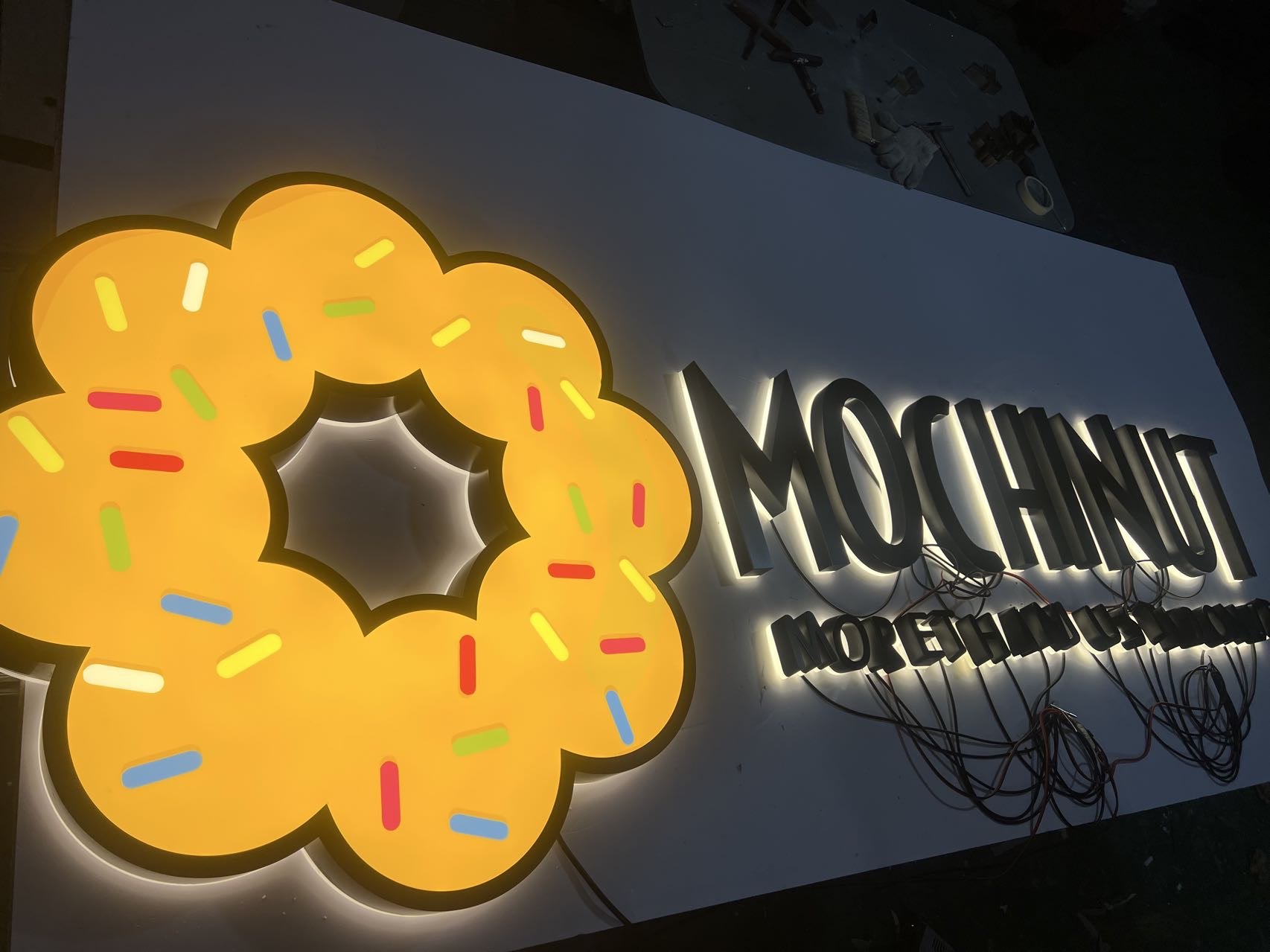 Factory lighting test of a custom logo sign and halo-lit dimensional letters